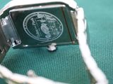 a close up of a watch on a green surface