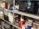 a kitchen with a lot of dishes and a microwave on the shelf