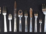 a lot of forks and spoons that are on a table