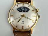 a close up of a wrist watch with a brown leather strap