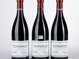 trois bouteilles de vin rouge posées côte à côte sur une table
