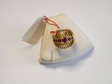an image of a gold ring with purple stones on a white plate