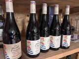 bottles of wine are lined up on a shelf in a wine shop