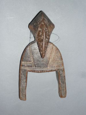 une sculpture en bois représentant une personne assise sur une chaise