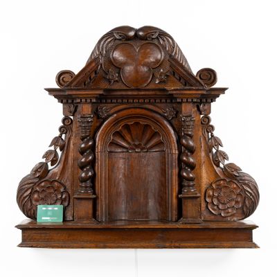 une horloge ancienne dotée d'un cadre en bois sculpté et d'une porte en bois
