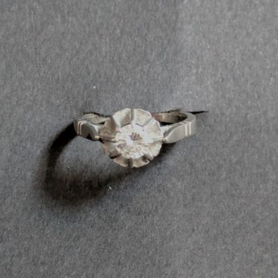 a ring with a diamond on it sitting on a table