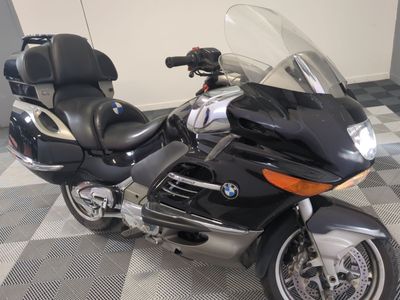 moto garée sur un sol en dalles à damier dans un garage