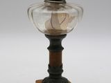 une lampe à huile à l'ancienne, dotée d'un abat-jour en verre et posée sur un socle en bois