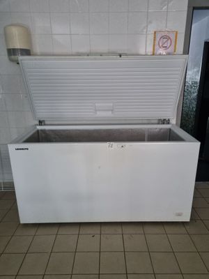 a white chest freezer sitting on a tiled floor