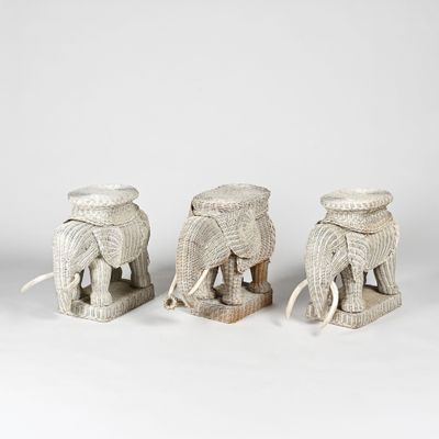 trois figurines d'éléphants blancs sont assises les unes à côté des autres