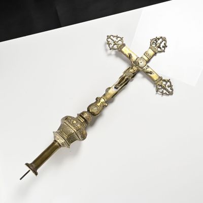 brass crucift on a white surface with a black background
