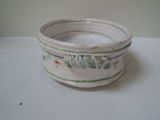 a white bowl with green and red designs on it