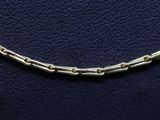 a close up of a silver chain bracelet on a blue leather surface