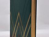 a green book with gold lines and a black cover