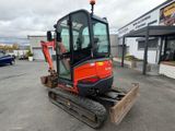 an image of a small excavator parked in a parking lot