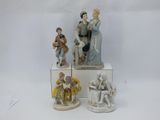 quatre figurines en porcelaine représentant des personnes assises sur une boîte blanche