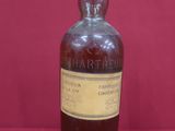 une vieille bouteille de whisky posée sur une surface rouge