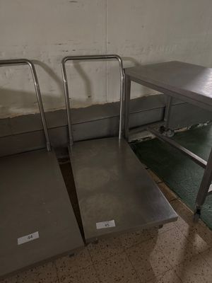 deux tables en acier inoxydable et un banc en métal dans une pièce