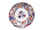 a plate with a floral design on it on a stand