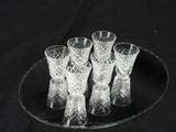 six glasses on a glass plate on a black table