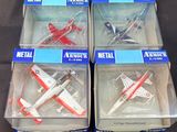 quatre maquettes d'avions en plastique se trouvent dans une boîte posée sur une surface noire