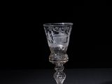 a wine glass sitting on a table with a black background