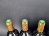 four bottles of wine are lined up in a row on a table