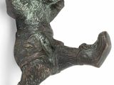 une figurine en bronze représentant un garçon jouant avec un frisbee
