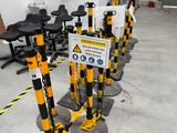 de nombreux poteaux jaunes et noirs sur lesquels sont accrochés des panneaux, dans une pièce