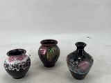 three vases that are sitting on a white surface
