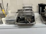 Plusieurs casseroles et poêles sont posées sur une cuisinière dans une cuisine.