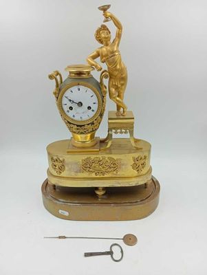 une horloge en or surmontée d'une statue