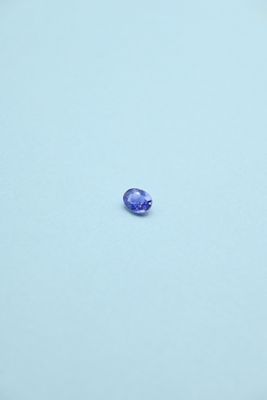 an oval blue sapphire stone sitting on top of a white surface