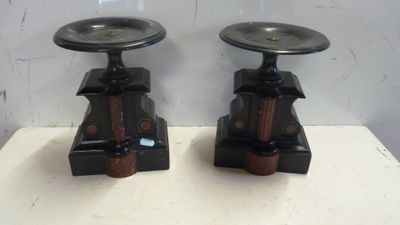 deux bougeoirs noirs posés sur une table blanche