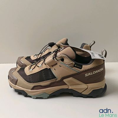 quelqu'un porte une paire de chaussures posée sur une table
