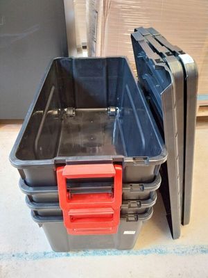 a stack of black and red plastic containers on the floor