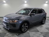 un SUV gris garé sur un sol à damier dans un garage