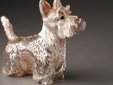 a silver dog figurine sitting on a table