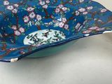 a blue bowl with flowers on it sitting on a table
