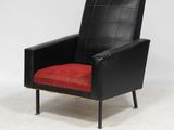 a black and red chair with a red cushion on a white floor