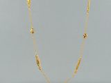 a gold plated necklace on a marble surface