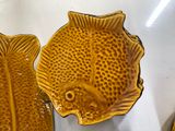 two yellow fish shaped dishes sitting on a table