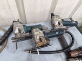 three electric tools sitting on a table next to a hose
