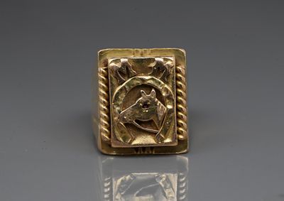 a close up of a gold ring with a horse on it