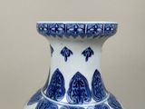 a blue and white vase sitting on top of a table