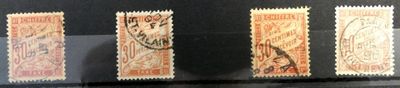 Trois timbres de couleurs différentes sont exposés dans une vitrine.