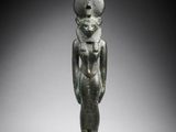 an egyptian bronze statue of a woman with a hat on her head