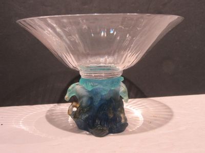 un vase en verre avec un socle bleu posé sur une table