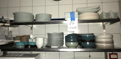 beaucoup d'assiettes et de bols sur les étagères de la cuisine