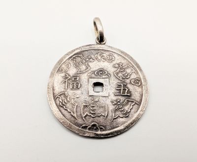 a close up of a silver coin on a white surface